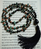 Full view of mala. 8mm rounds, 6mm rounds, and 5x15mm flat chip African Turquoise beads (Turquoise blue with black and brown colorations). Faceted black Onyx beads (8mm and 6mm). Copper Czech glass beads (6mm and 4mm). 6x25mm teardrop-shaped black Onyx guru with black sutra and tassel. One-of-a-kind, hand-knotted mala.