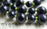 Close up view of deep Blue Goldstone beads. The copper flecks inside the beads sparkle like stars in the night sky. Apple green knots between the beads showcase and protect the beads of this one-of-a-kind design.