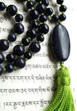 Close up view of 15x30mm oval Blue Goldstone Guru. An apple green tassel spills from the base of this bead adding vibrant color and beautiful contrast.
