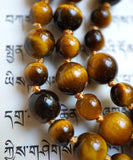 Tiger Eye beads with warm brown and gold hues. Honey gold knots between each bead showcase and protect the beads of this design in a beautiful way.