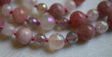 Close up view of 8mm faceted White Agate bead framed with 6mm Gray Agate beads along with 8mm Pink Tourmaline and 6mm faceted White Agate beads. Salmon pink knots between the beads of this mala help protect and showcase the beads.