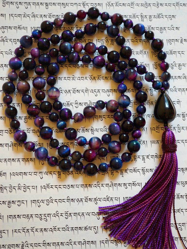 Full view of hand-knotted Rainbow Tiger Eye Mala with black teardrop-shaped guru and variegated purple tassel.