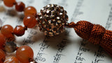 Close up view of spunky, funky 16mm copper "disco ball" guru. A cinnamon brown tassel spills from the base of this focal bead.