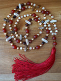 Full view of mala with 6mm light and dark cream Mother of Pearl beads, 6mm brushed gold Czech glass beads, 6mm Red Tiger Eye beads, 5x15mm center drilled light and dark brown Wood Opalite flat chip beads, 8mm matte Carnelian beads with double Carnelian guru separated by a gold spacer bead and deep red sutra and tassel.