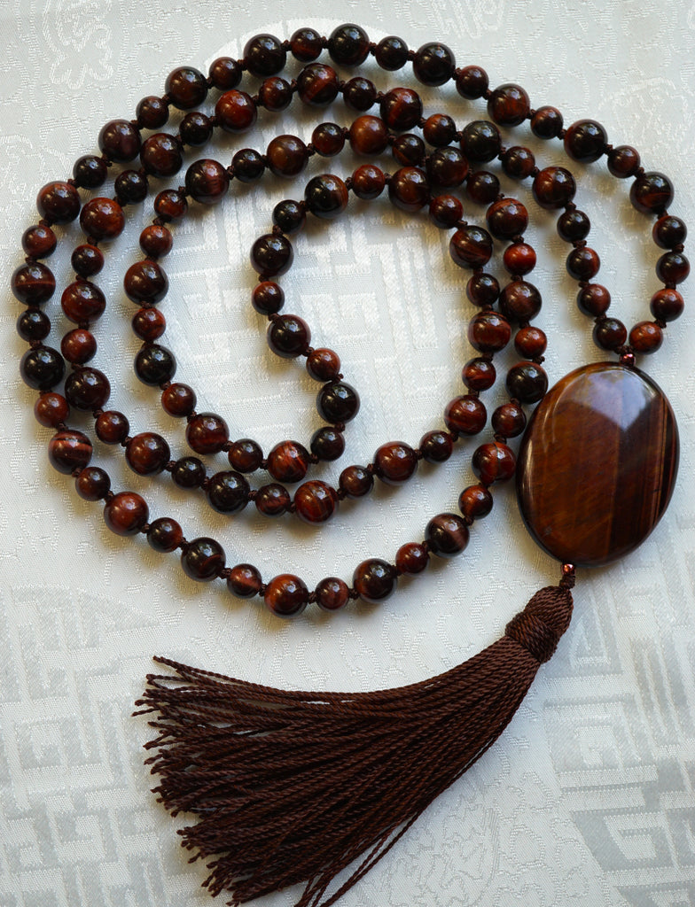 Full view of Red Tiger Eye Mala. Alternating 6mm and 8mm deep red Tiger Eye beads with 15x30mm oval Red Tiger Eye guru and chocolate Brown sutra and tassel.
