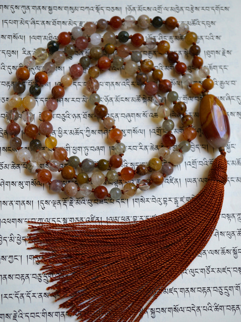 Full view of Rutilated Quartz Mala with oval Chalcedony guru and cinnamon brown sutra and tassel.