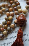 Close up view of 6x24mm bicone shaped Bayong wood guru. This light brown bead  with horizontal lines carved into the bead add texture, visual interest, and harmony to this design.