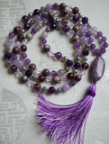 This mala is a beautiful medley of purple beads, including Amethyst, Lavender Amethyst, Cacoxenite, and Porcelain Jasper, along with gray Labradorite and clear, star-cut Quartz beads.