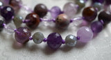 Close up view of 8mm faceted Purple Amethyst framed with faceted 6mm Labradorite beads. Translucent purple Cacoxenite on the left; Lavender Amethyst on the right; and knots in between beads to protect and showcase the beads of this beautiful design.