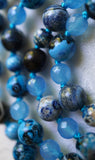 Close up view of Azure Agate and Aqua Jade beads. The parrot-blue knots showcase and protect the beads of this design.