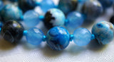 Close up view of Azure Agate bead framed by faceted Aqua Jade beads. Parrot-blue knots protect and showcase the beads of this design beautifully.