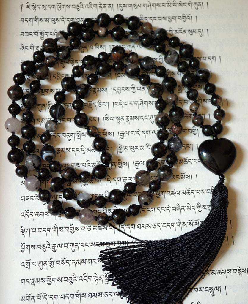 Calico Tourmaline beads include black, brown and white hues. The heart-shaped Obsidian guru brings this elegant mala full circle. A black tassel spills from the base of this hand-knotted mala.