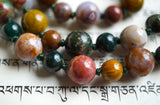 8mm and 6mm Kabamby Ocean Jasper beads in dark green, mustard yellow, red, mauve, and white. Deep sea green knots between the beads protect and showcase the beads of this design beautifully.