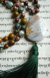 25x35mm flat, teardrop-shaped Kabamby Ocean Jasper guru. White with light brown accents, this unique bead brings this design full circle with a deep sea green tassel spilling from the base.