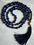 Full view of Lapis Lazuli Mala with dark cobalt blue Lapis  beads (6mm and 8mm) and two rondelle beads framed with faceted gold metal beads at the quarter and three-quarter mark. A textured gold metal guru brings this design full circle along with a navy sutra/tassel.