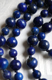 Close up view of alternating 6mm and 8mm Lapis Lazuli beads. The navy knots between each bead showcase and protect the beads of this one-of-kind design.