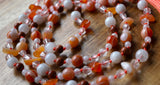 Beautiful blend of white, orange, and brown beads. The knots protect and showcase the beads  in this design..
