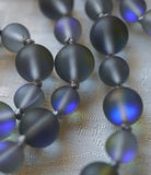 Close up view of matte Gray Mystic Aura beads with cobalt blue flashing. Dove gray knots between beads protect and showcase the beads of this design.