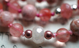 Close up view of 8mm faceted White Agate rondelle framed with 4mm rose Czech glass beads; 6mm Cherry Quartz; 8mm Rhodochrosite; 8mm faceted Cherry Quartz rondelles framed with 4mm faceted silver Czech glass beads. 