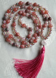 Hand-knotted mala with 8mm Pink Tourmaline, faceted White Agate, and faceted Gray Agate beads with globe-shaped matte Quartz guru and bright pink tassel.