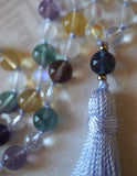 Close up view of 8mm Blue Fluorite guru with powder blue tassel spilling from the base of the bead.