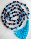 Full view of mala with deep purple and blue Rainbow Tiger Eye beads, light blue faceted Aqua Jade, and purple Amethyst beads with a parrot-blue sutra and tassel.