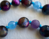 Another beautiful example of chatoyancy: beautiful bands of light create a luminous shimmer on these Rainbow Tiger Eye beads. Flanked by faceted blue Aqua Jade and matte Amethyst beads--a beautiful combination of color, texture, and shine.