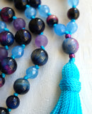 Close up view of Rainbow Tiger Eye guru.  The luminous blue and purple bands of light, or chatoyancy, of these beads adds a beautiful shimmer and shine to this mala design.