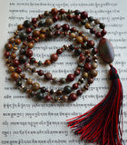 Full view of Red Creek Jasper Mala with 8mm, 6mm, and 3x6mm saucer shaped beads framed with gold metal spacer beads. A 15x30mm oval Red Creek Jasper guru brings this design full circle with a variegated red/black tassel