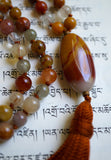 Oval Chalcedony guru with orange, red, and white hues brings this design full circle, along with the cinnamon brown tassel that spills from the base of this focal bead.