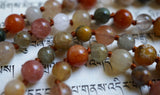 Close up view of Rutilated Quartz beads in red, orange, gray, white, and yellow hues. The cinnamon brown knots between the beads protect and showcase the beads beautifully.
