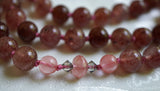 Close up view of 6mm pink Cherry Quartz beads and an 8mm Cherry Quartz rondelle framed with 4mm bicone crystals. This bead unit marks the quarter mark of the mala. Another similar unit marks the three-quarter mark to add visual interest color, and texture to this design.