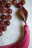 A twisted spiral Mookaite Jasper guru with hints of red, burgundy, and ochre bring this design full circle. A dusty rose tassel spills from the base of this focal bead.