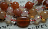 Two oval Carnelian beads (10x14mm) framed with clear Swarovski crystals mark the quarter and three-quarter marks of this design, adding elegance and visual interest to this mala. 